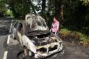 LUCKY TO BE ALIVE: Rosalyn Gibbs by her burnt out car.