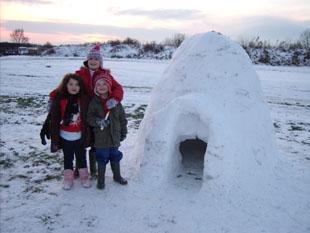 Madison and  Kyle Lane and Savannah Evens outside their completed igloo.