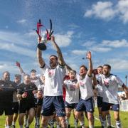 Captain Mark Armstrong hoists the trophy high. Picture: Debbie Gould