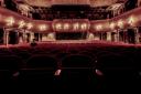 A grand theatre with rows of empty seats. Credit: Canva