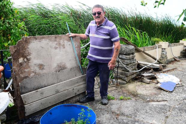 Bridgwater Mercury: Ray Brown with rubbish left behind from flooding ; Stafford Road, Bridgwater